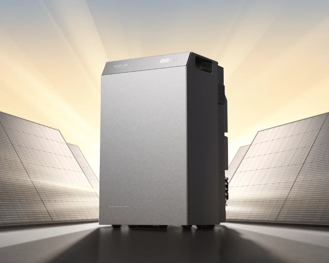 Grijze EcoFlow-batterij in het licht van de ondergaande zon, tussen twee zonnepanelen.